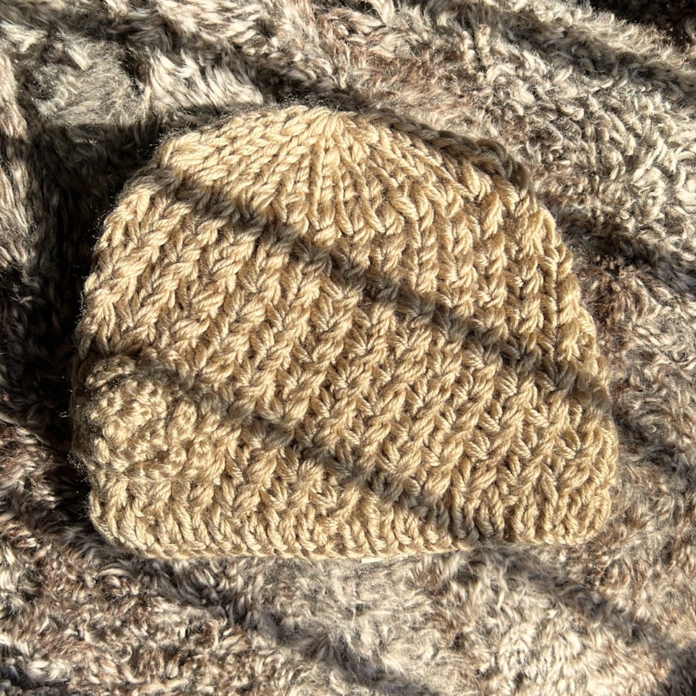 A very cozy and tightly knit winter hat with a knitted flower attached.